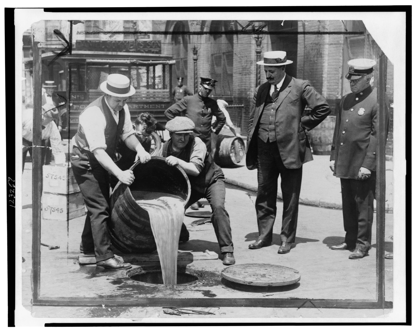 New York City Deputy Police Commissioner John A. Leach (right) watching Prohibition agents pour liquor into the sewer following a raid, c. 1921. The visible-public-destruction of seized liquor was a regular media event during the Prohibition era (1920–1933)