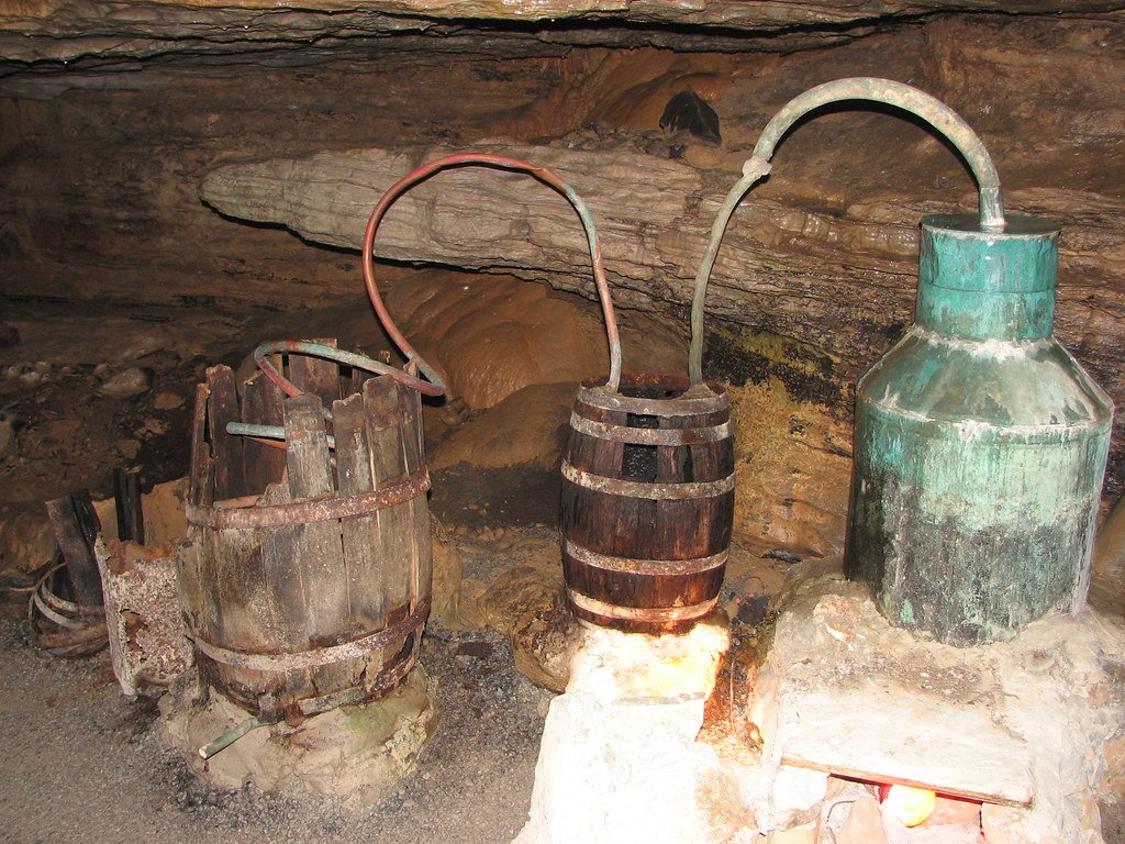 Photo of a complete Tier-2 bench setup — copper or stainless 15-gallon kettle with mounted column, condenser, parrot, PID controller, and electrical connection visible