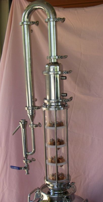 A StillDragon 4-inch tri-clamp modular column with bubble-cap plate sections and a dephlegmator on top — representative of the modular construction philosophy that defines Tier-3-scale reflux equipment