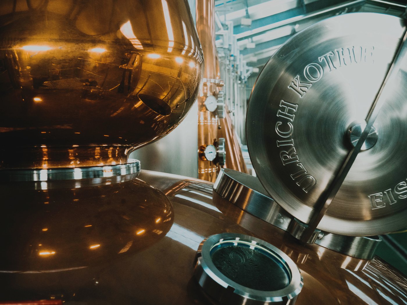 A complete Tier-5 dedicated whiskey rig — 20-gallon copper still on a stand with HLT, mash tun, fermenters, pumps, and pipework visible in a dedicated workshop space
