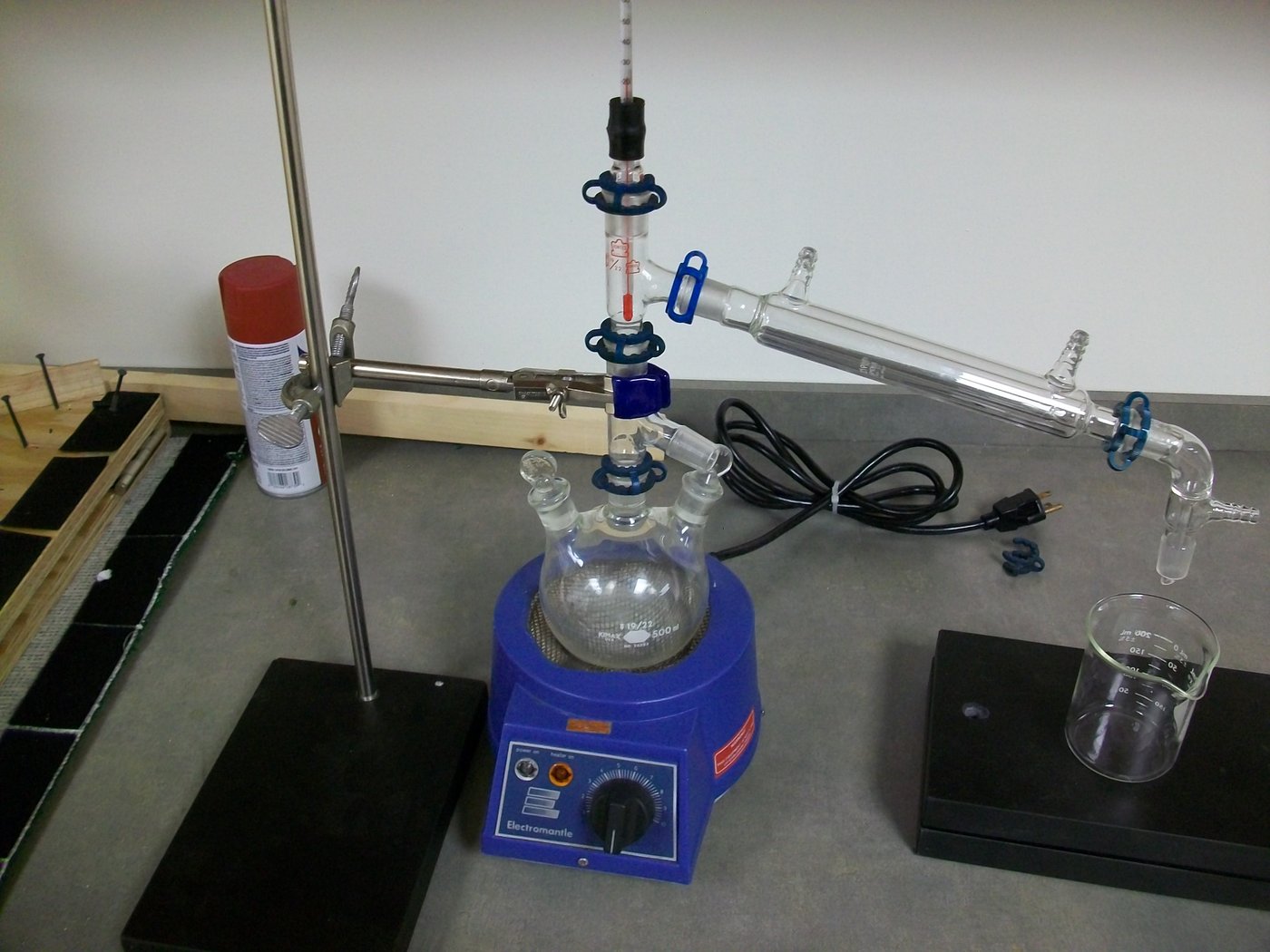 Tier-5 neutral-spirit dedicated rig — tall multi-plate sight-glass column with dephlegmator on a 25-gallon stainless kettle, parrot at the output, showing the full vertical reflux setup